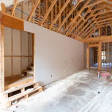 Exterior view of a modern two-story home under construction in Los Angeles with exposed wooden roof framing and wall structures, showcasing a new residential build by Best Construction LA.