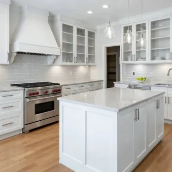 Modern luxury kitchen remodel in Los Angeles featuring custom white cabinetry, a large marble waterfall island, and professional-grade stainless steel appliances by Best Construction LA.