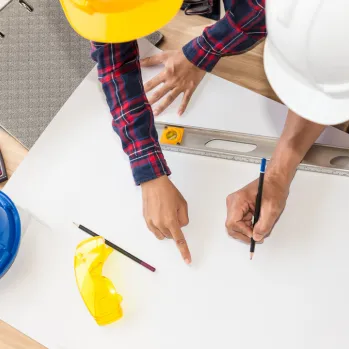 Wide shot of a new residential house frame with exposed wooden roof trusses during a construction project.