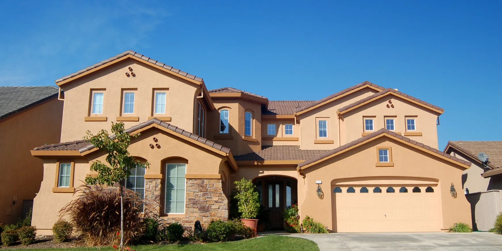Luxury custom home in Los Angeles completed with stucco exterior, tile roofing, landscaping, and modern design